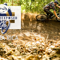 Mountain biker in a right handed berm, with a trail of dust behind him and the Underexposed logo with Costa Rica beneath of it.